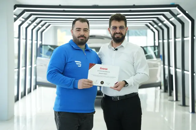 Belgede eğitim adı “Car Detailing”, tarih alanı 22/02/2025 olarak görünüyor. Kare, koridorun LED kemerleri altında çekilmiş.