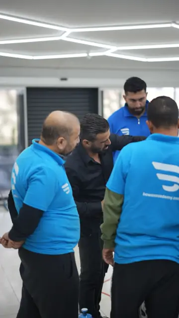 Atölyenin ortasında dört kişi bir araya gelmiş; ayaklarının dibinde kayganlaştırıcı için kullanılan mavi el pompası duruyor. Aynı araç üzerinde birden fazla kişinin çalıştığı uygulamalarda sıranın ve görev paylaşımının önceden netleşmesi gerekir.