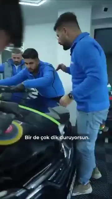 Dik durmak ilk bakışta rahat görünüyor ama yüzeyi göstermiyor. Öğrenci yanına çağrılıp aynı noktaya hocanın açısından baktırılıyor; dik duruşta yalnızca tek bir şey görünüyor.

Açı değişince görülen de değişiyor. Makine hafifçe geri çekildiğinde pasta keçenin altına alınıyor ve o ana kadar görünmeyen çizik ortaya çıkıyor.

Çalışma açısı konforla değil, yüzeyi okuyabilmekle ilgili bir tercih.