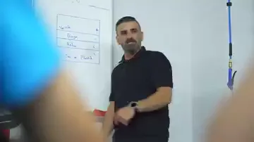 Beyaz tahtaya üstten alta doğru dört satır yazılmış: vernik, boya, astar, sac ve plastik. Siyah tişörtlü bir kişi tahtanın yanında durup bu sıralamayı anlatıyor, kadrajın kenarında katılımcılar oturuyor. Sıralama tesadüfi değil; yüzeyde çalışırken en üstteki katman en ince olandır. Yapılacak her işlem, hangi katmana dokunulduğunun bilinmesini gerektiriyor.