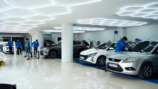 Oto detailing eğitimlerinin yapıldığı altıgen aydınlatmalı uygulama atölyesi; her aracın çevresinde rahatça çalışılacak kadar boşluk bırakılmış.