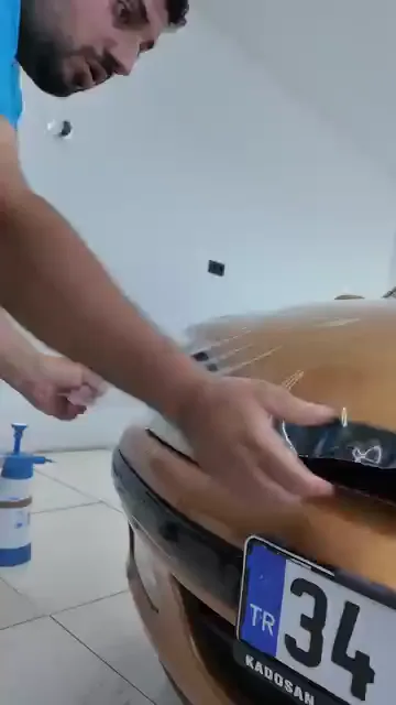 Film, çalışılan parçanın adı ekranda belirtilerek bölüm bölüm uygulanıyor: “Çamurluk”, ardından “C Sütunu”. Far ve ayna gibi çıkıntılı yüzeylerde film ısıyla yumuşatılıp forma sokuluyor, sonra ragleyle sabitleniyor. Panel panel ilerlemek, filmin her bölümde kendi geometrisine göre gerilmesini sağlıyor.