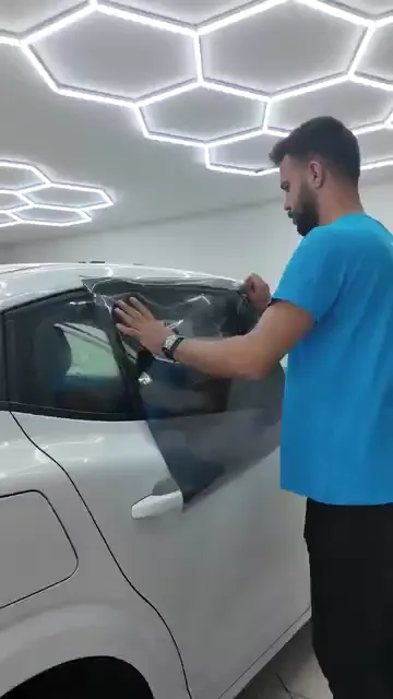 Film cama serildikten sonra üst kenardan başlanarak bastırılıyor; camın kavisi boyunca ilerlerken fazlalık dışarıda bırakılıyor. Kesim cam kenarına dayanarak değil, birkaç milimetre içeriden yapılıyor. Bitmiş camda tavan aydınlatmasının kesintisiz yansıması, filmin altında hava kalmadığını gösteriyor.