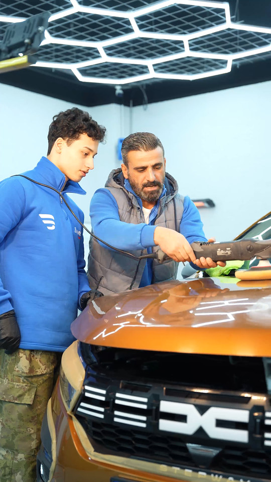 Eğitmenimiz, polisaj makinesinin kaput üzerinde nasıl yönlendirileceğini kursiyerimizle aynı makinede birlikte çalışarak gösteriyor.
