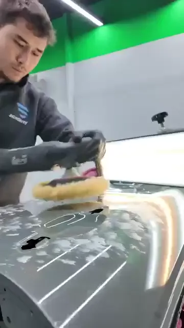 Çalışma, sökülüp tezgâha alınmış panele pasta sürülmesiyle başlıyor; ardından yuvarlak pedli makine yüzeyde geziyor ve ara ara yüzey siliniyor.

Kenarlar maskeleme bandıyla ayrılmış, sonuç ise geniş ışık paneli önünde eğilerek kontrol ediliyor. Toyota C-HR'ın arka kapağı ve iç bölümü de aynı akışta görünüyor.

Videoda konuşma yok; sıralama tamamen karelerden okunuyor.