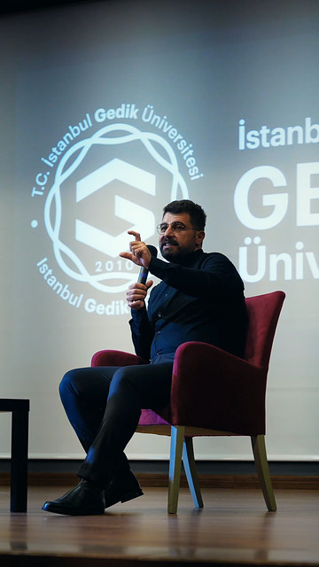 Bowax kurucusu Lokman İn, İstanbul Gedik Üniversitesi konferans salonunda sahneden öğrencilere konuşuyor; Bowax Academy öğrenci buluşmasından görüntüler.