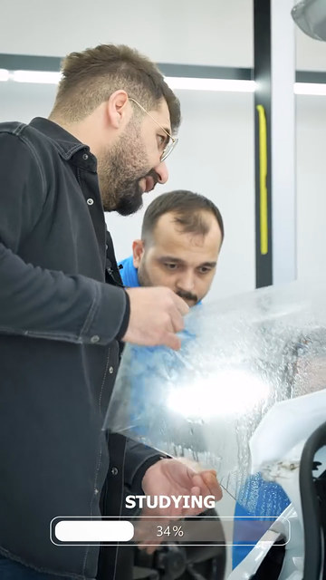 PPF kaplama eğitiminde kapı ve çamurluğa film uyguluyor, kenarlarını kapatıyoruz; ragle kullanımını kursiyerlerimize uygulamada öğretiyoruz.