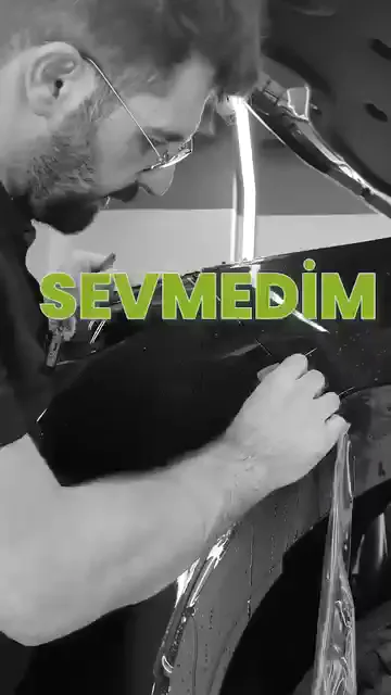 Ekrandaki not tek cümle: “Sevmedim burayı!” Takılınan yer, çamurluk ile tekerlek davlumbazının birleştiği kıvrım; film burada bolca kayganlaştırıcıyla yeniden ıslatılıp ragleyle tekrar çalışılıyor. Şeffaf filmde bir kenarın kabul edilip edilmeyeceği uzaktan değil, ışığa eğilerek anlaşılıyor.