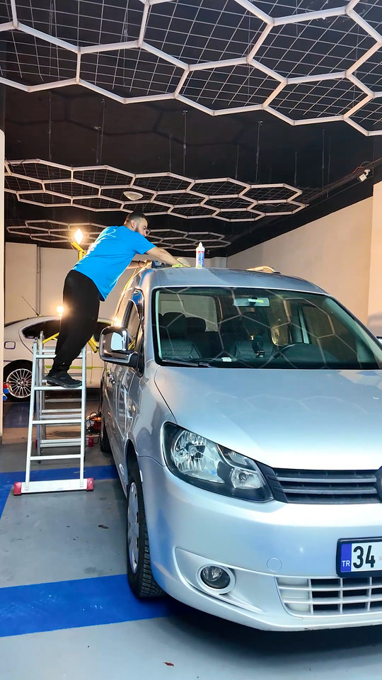 Ticari aracın yüksek tavanına merdivenle çıkıp pasta cila yapıyoruz; fitilleri ve çıtaları işe başlamadan önce bantla kapattık.