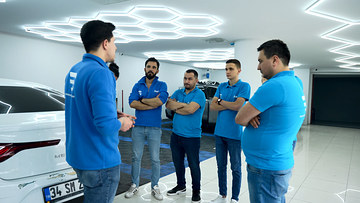 Oto detailing eğitiminde uygulamaya başlamadan önce eğitmenimiz, araç başında kursiyerlerimize yapılacak işi anlatıyor; altıgen aydınlatmalı atölyemizden.