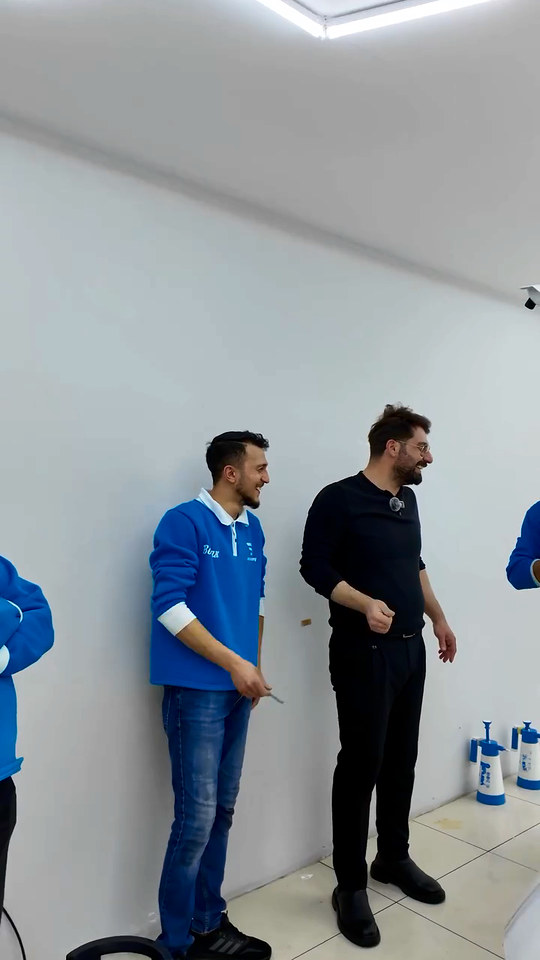 PPF eğitiminde kursiyerlerimiz arka tampon ve bagaj kenarı gibi zor bölgelere film uyguluyor; filmin zorlandığı yerlerde buhardan destek alıyorlar.