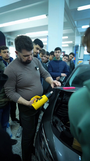 Ege Üniversitesi söyleşisinde otomotiv mesleklerini konuşan Lokman İn, ardından araç başında öğrencilere PPF kaplamanın temel adımlarını uygulattı.