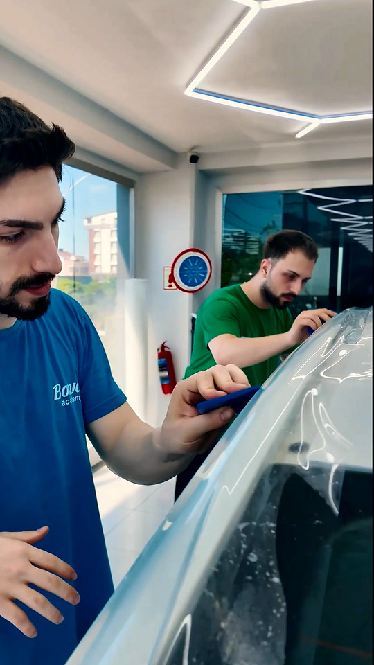 PPF kaplama eğitiminde kursiyerimiz kavisli panele uyguladığı şeffaf filmi yüzeye konumlandırıyor.
