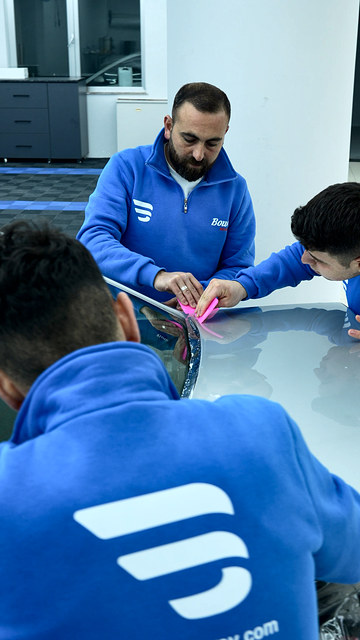 Bowax Academy PPF dersinde eğitmenimiz ve kursiyerimiz kaputa uyguladıkları filmi birlikte yerine konumlandırıyor.