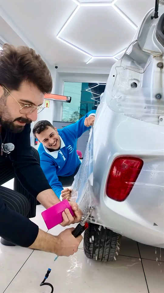 Arka tampon ve çamurluk hattına uyguladığımız filmi kıvrımlara doğru geriyoruz; eğitmenimiz PPF uygulamasını araç başında yönlendiriyor.