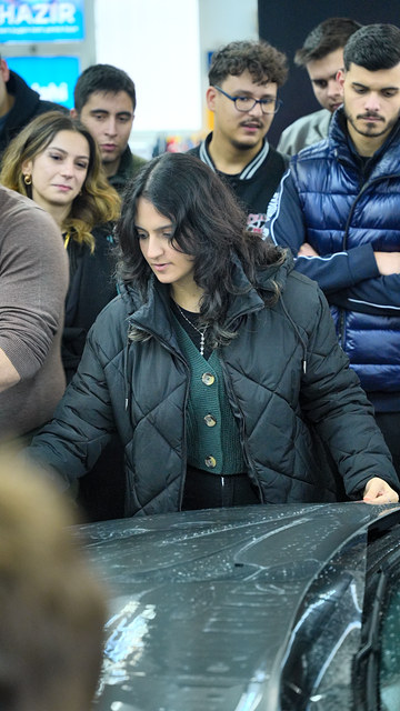 Lokman İn'in anlattıklarından sonra bir öğrenci PPF kaplamayı kendisi deniyor; Ege Üniversitesi söyleşimizden.