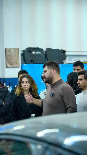Ege Üniversitesi söyleşimizde Bowax kurucusu Lokman İn, otomotiv laboratuvarında araç başında öğrencilere PPF kaplamayı anlatıyor.
