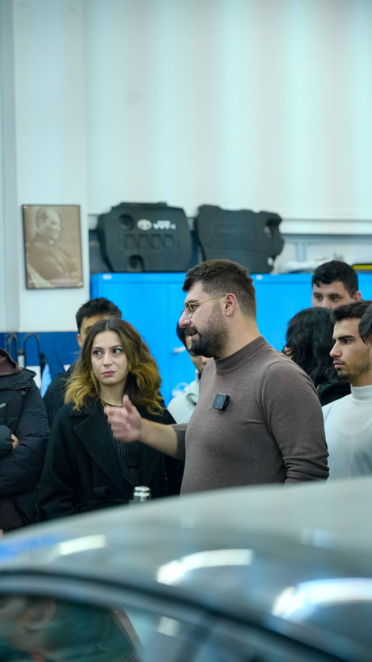 Ege Üniversitesi söyleşimizde Bowax kurucusu Lokman İn, otomotiv laboratuvarında araç başında öğrencilere PPF kaplamayı anlatıyor.