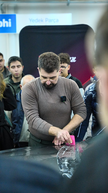 Ege Üniversitesi'ndeki eğitimde Lokman İn kaputa uyguladığı PPF filminin kenarını kapatıyor.